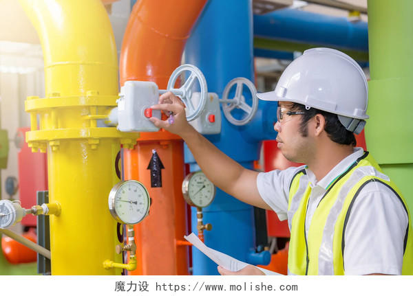 亚洲工程师戴眼镜工作在锅炉房维修检查供热系统设备的技术数据